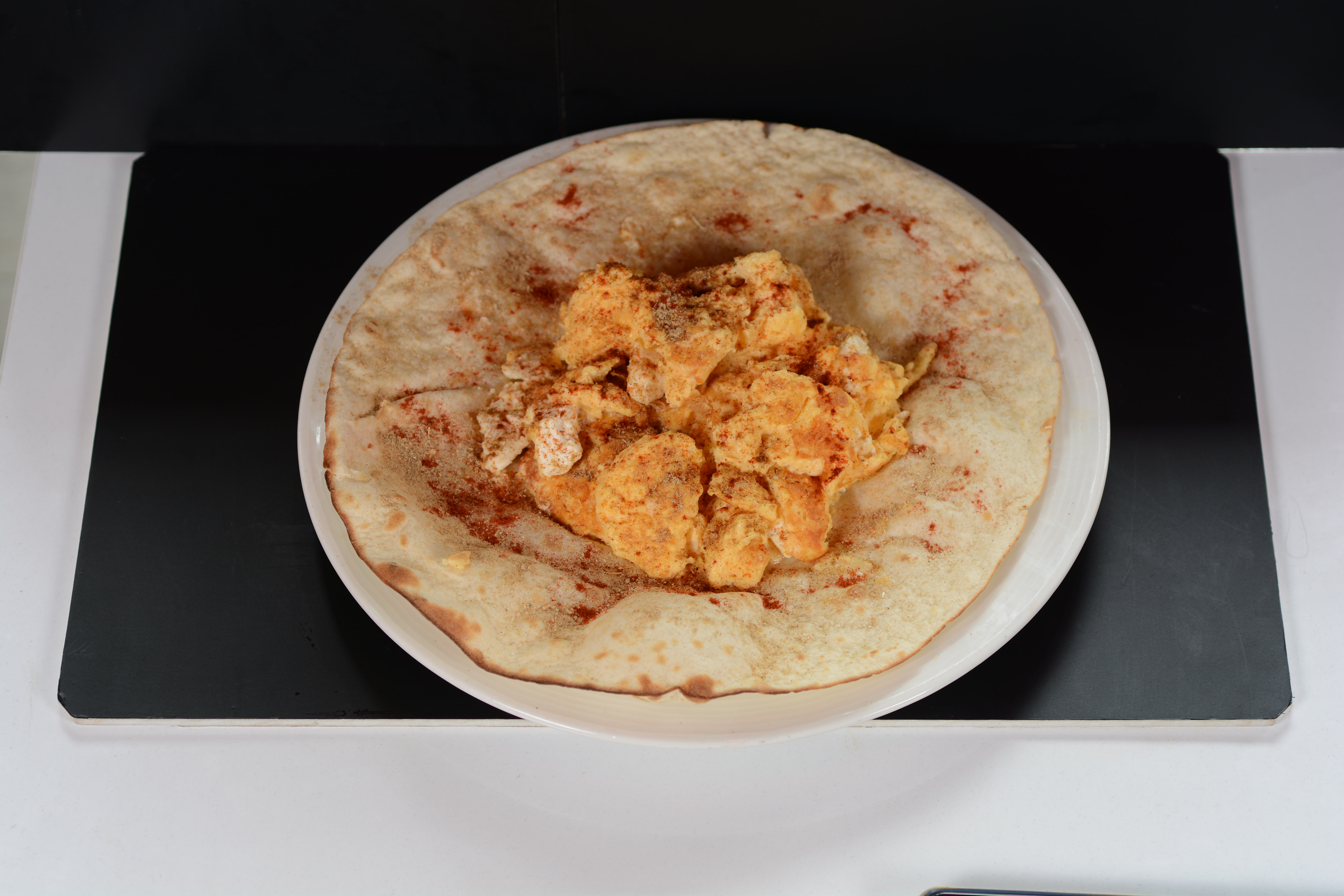 Бъркани яйца със сирене върху арабска питка